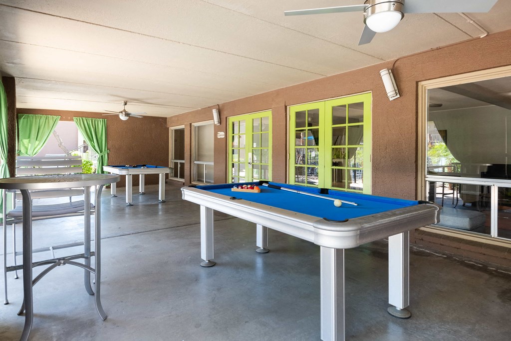 a game room with a pool table and a bar