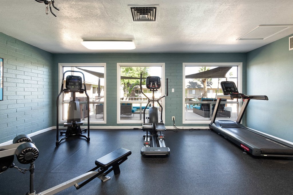 a gym with exercise equipment and windows at the resort at longboat key club