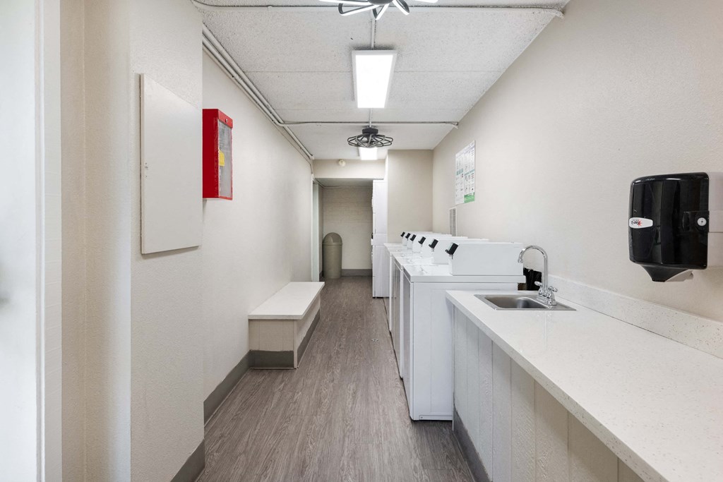 a long white room with a sink and a counter top