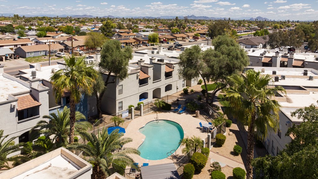 an aerial view of a community with a pool and palm trees