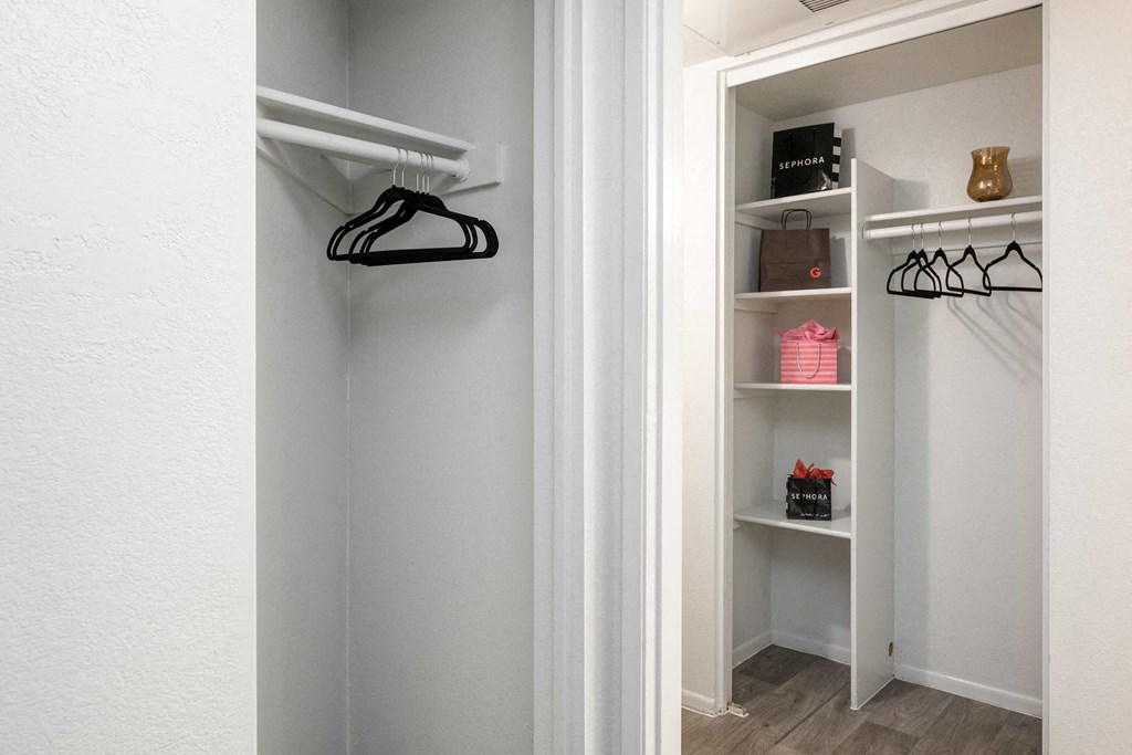 a walk in closet with shelves and a hanger on the wall