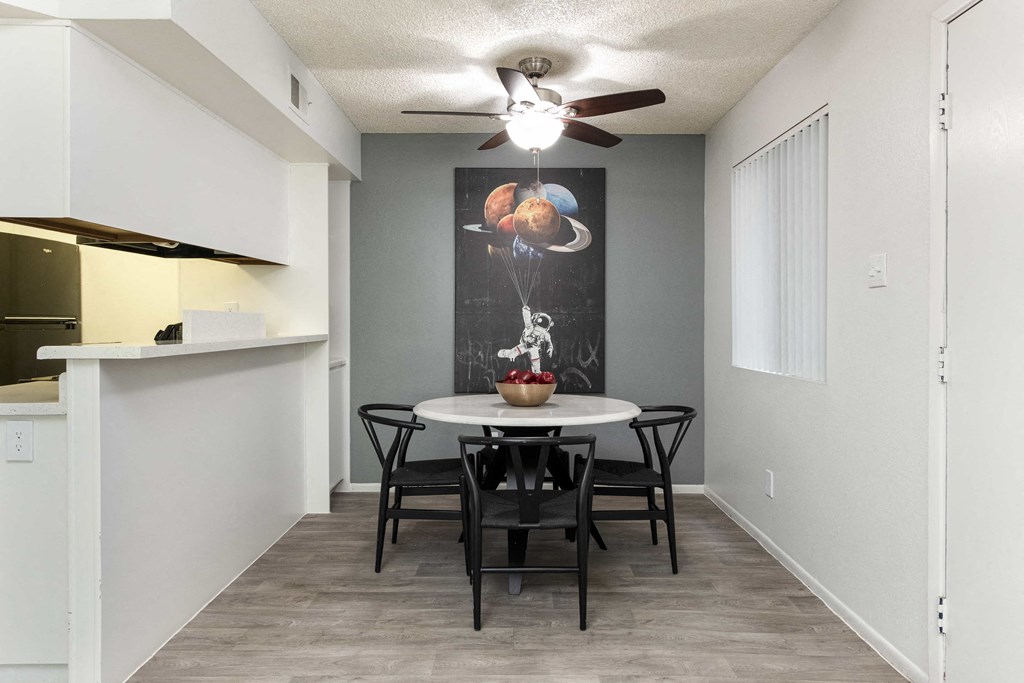 a dining room with a table and chairs and a ceiling fan