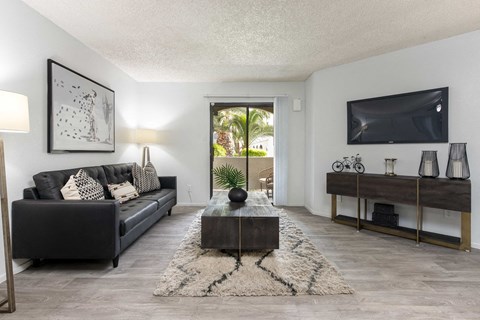 a living room with a black couch and a tv