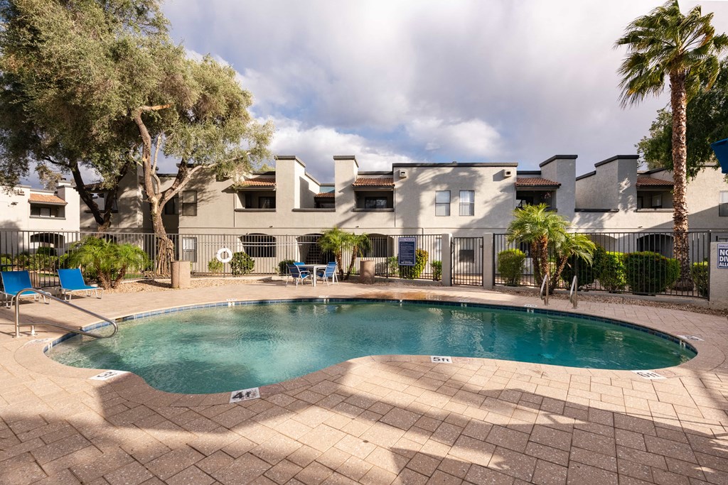 a swimming pool with a house in the background