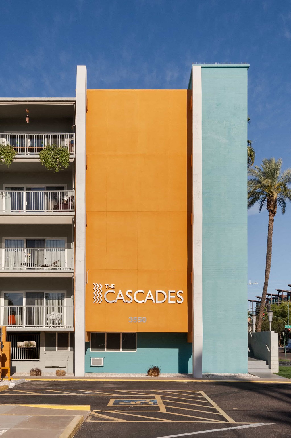 A building with a yellow facade and a sign that says "The Cascades".