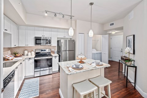 A modern kitchen with white cabinets and a central island.