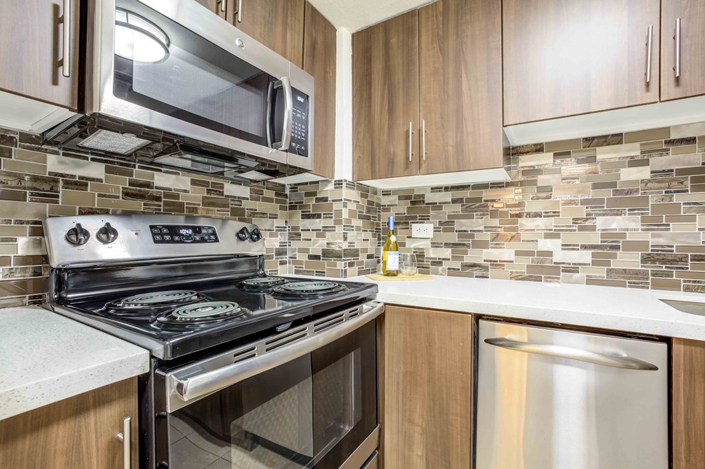 A kitchen with a stove top oven and microwave above it.
