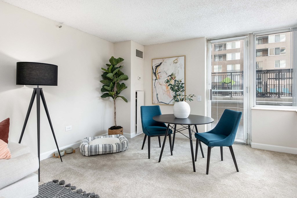 a living room with a table and chairs and a window