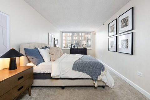 a bedroom with a bed and a dresser and a window