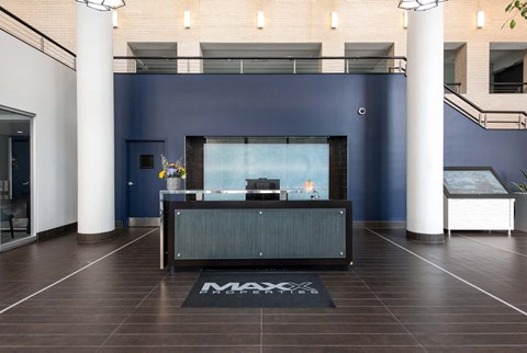 a reception desk in a lobby with a blue wall and white pillars