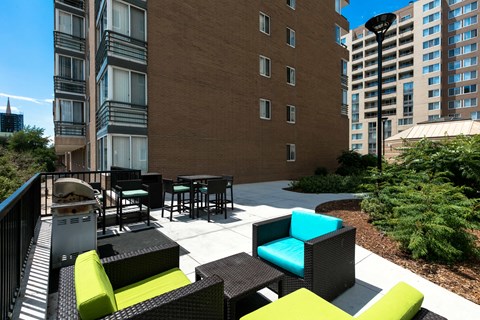 a patio with chairs and tables in front of a building