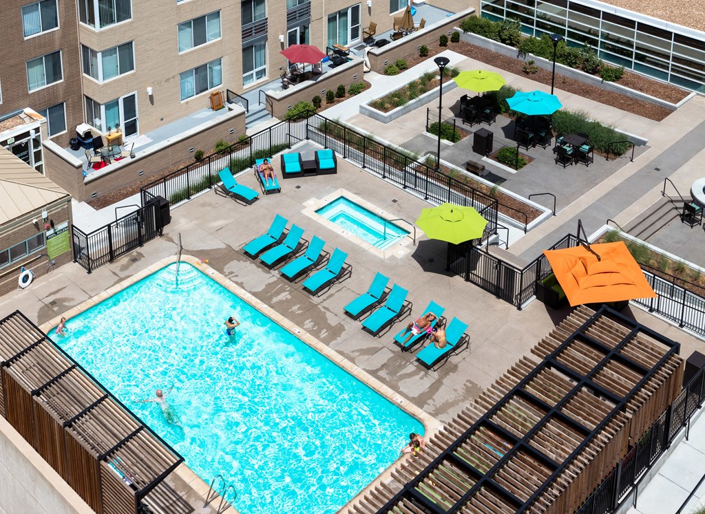 an overhead view of a swimming pool with chairs and umbrellas