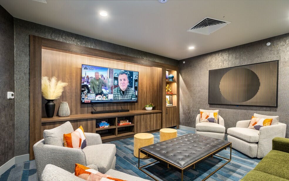 A modern living room with a flat screen TV mounted on the wall.