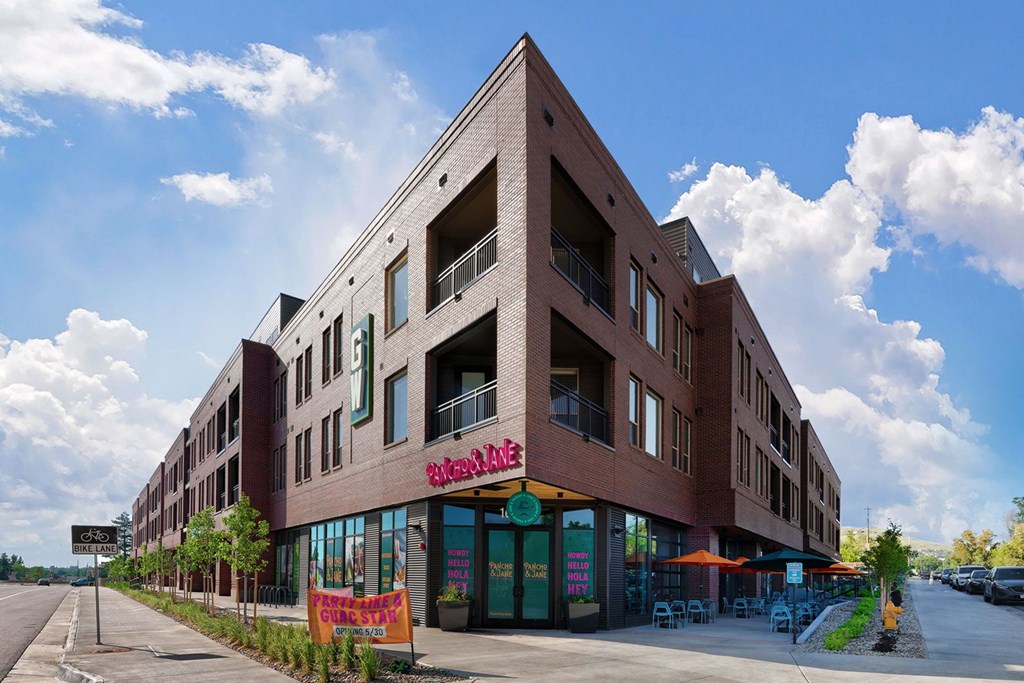 A large brick building with a red awning and a sign that reads