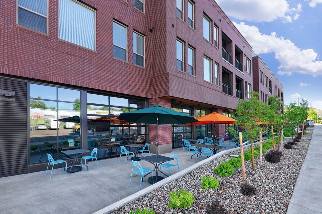 A red brick building with tables and chairs outside.