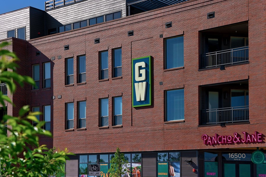 A red brick building with a green sign that says GW on it.