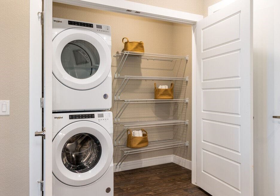 A white dryer and washer are in a small laundry room.