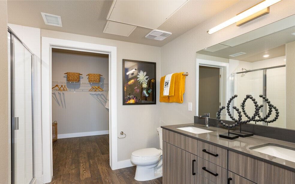 A bathroom with a toilet, sink, and mirror.