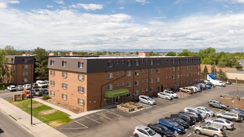 an aerial view of a building with a parking lot full of cars