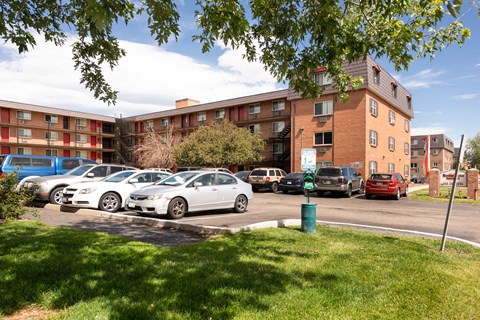 a parking lot with cars in front of an apartment building
