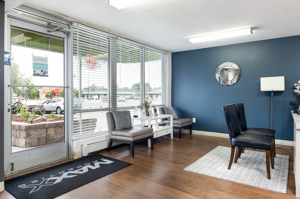 a living room with blue walls and a window with chairs and a table