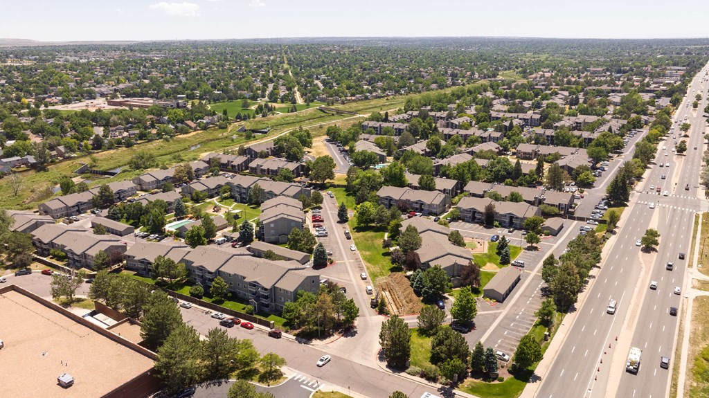 an aerial view of a suburban neighborhood with cars on the street and residential houses
