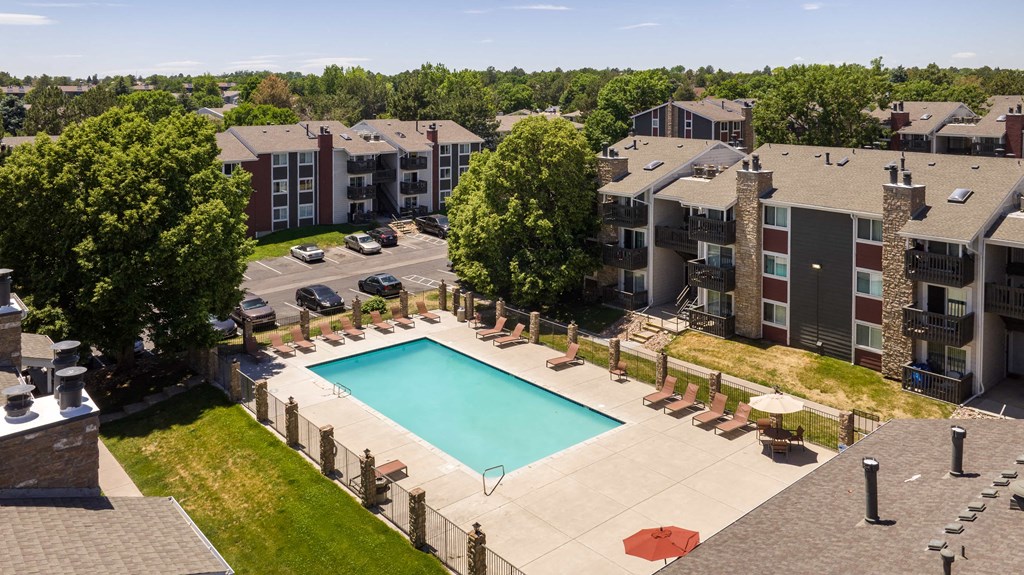 an aerial view of a swimming pool with apartments in the background