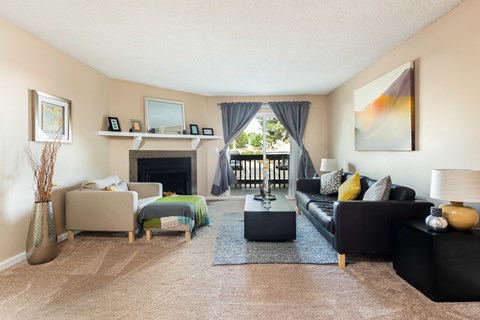 a living room with a couch and chairs and a fireplace