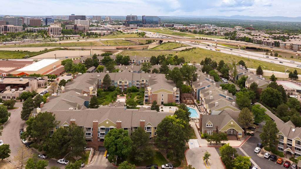 an aerial view of a neighborhood with houses and a city in the background