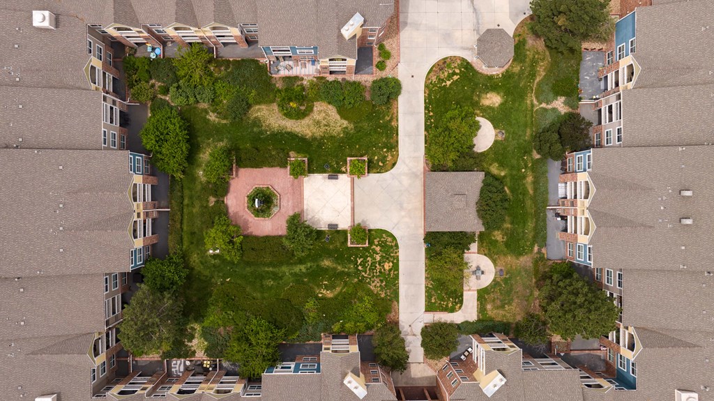 an aerial view of a building shaped like a face with grass and trees