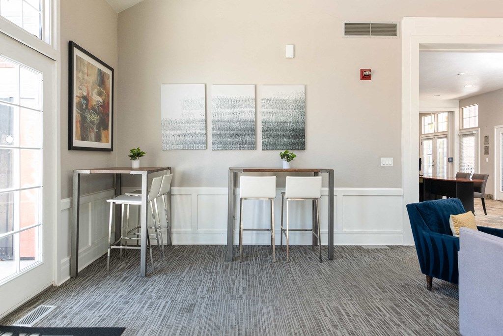 a living room with two bar stools in front of a window and a couch