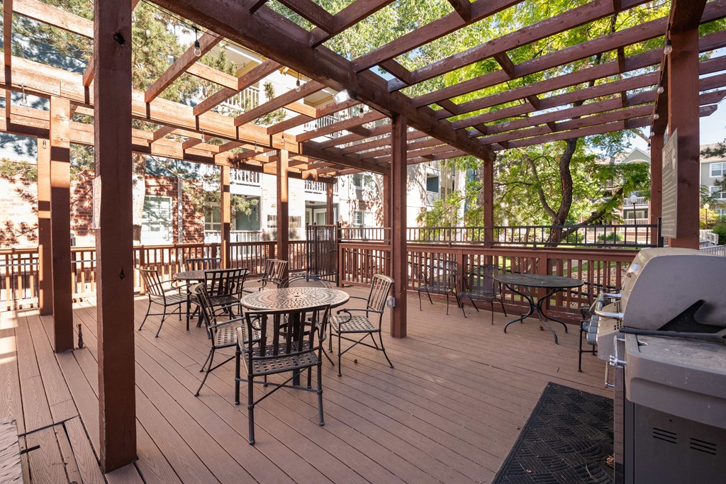 a patio with tables and chairs and a wooden deck