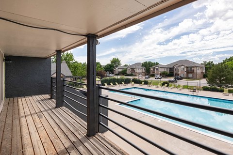 the view of a swimming pool from a balcony with wooden decking