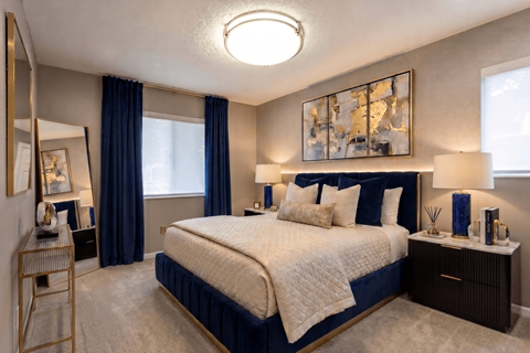 A bedroom with a large bed and a painting above it.