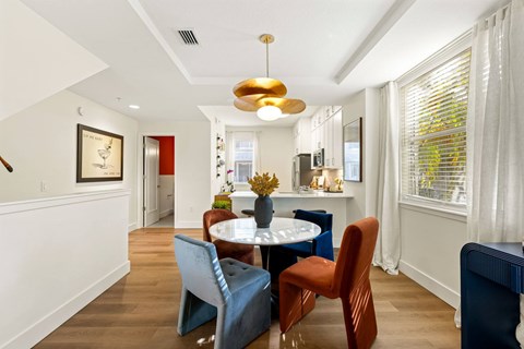 A dining room with a table and chairs.
