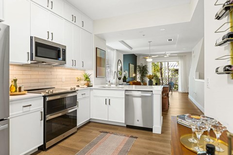 A kitchen with white cabinets and appliances.