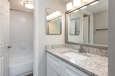 A bathroom with a white tub and sink.