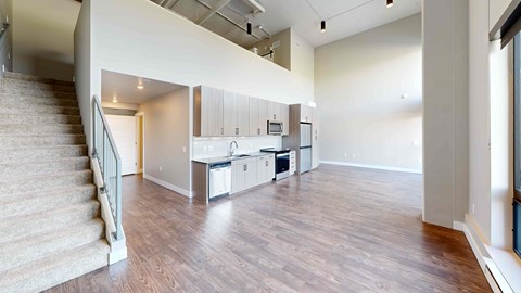 A spacious living room with a staircase on the left side.