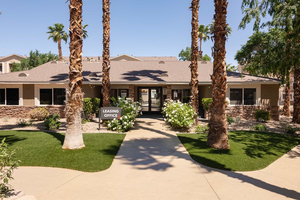 a house with palm trees and a sign in front of it