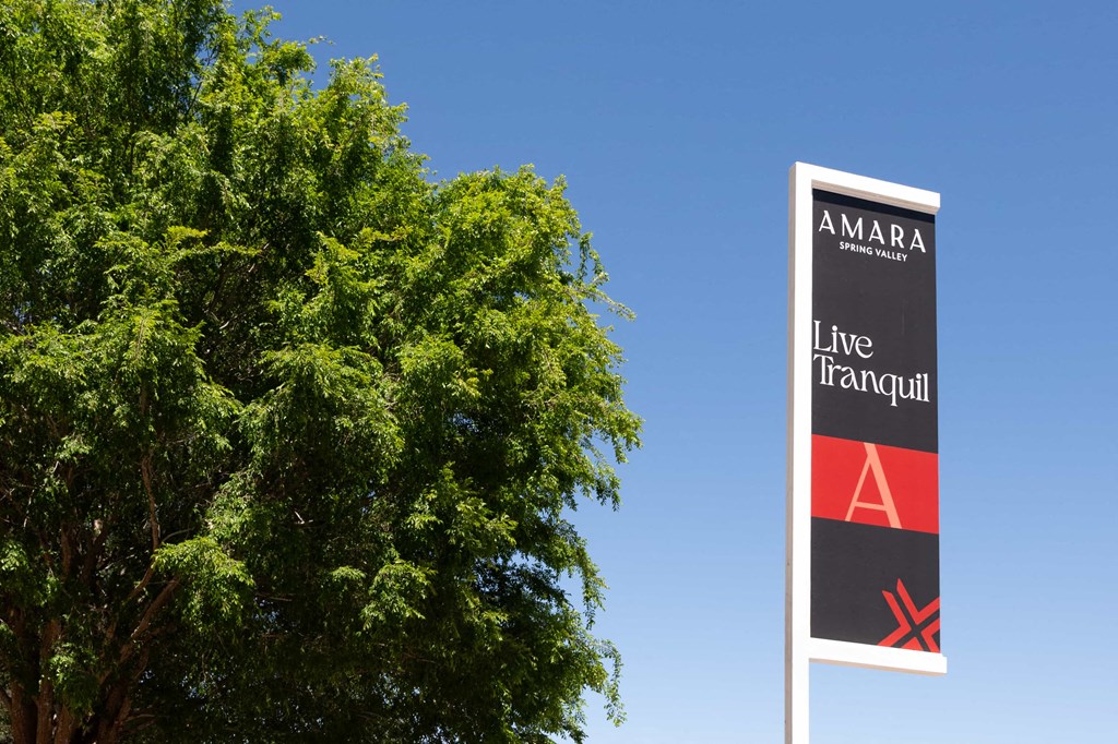 a sign for the line tram stop in front of a tree