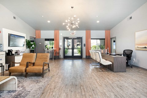 a living room with chairs and a table and a door to a lobby