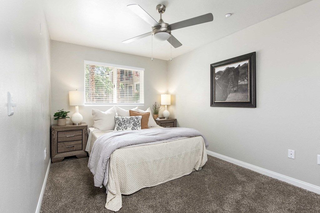 a bedroom with a bed and a ceiling fan