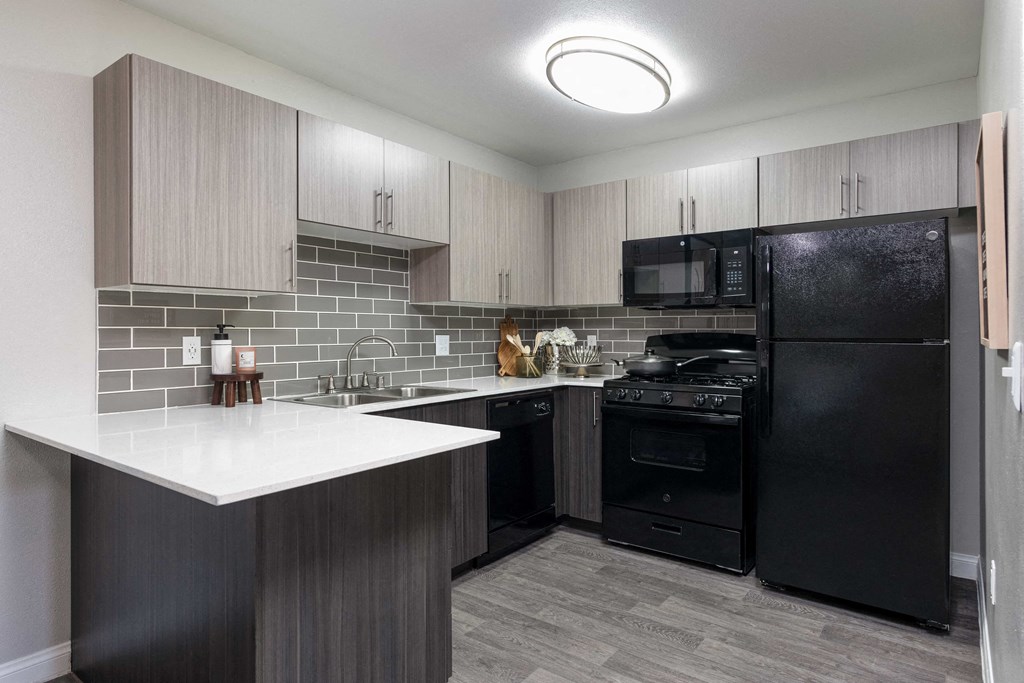 a kitchen with black appliances and a white counter top