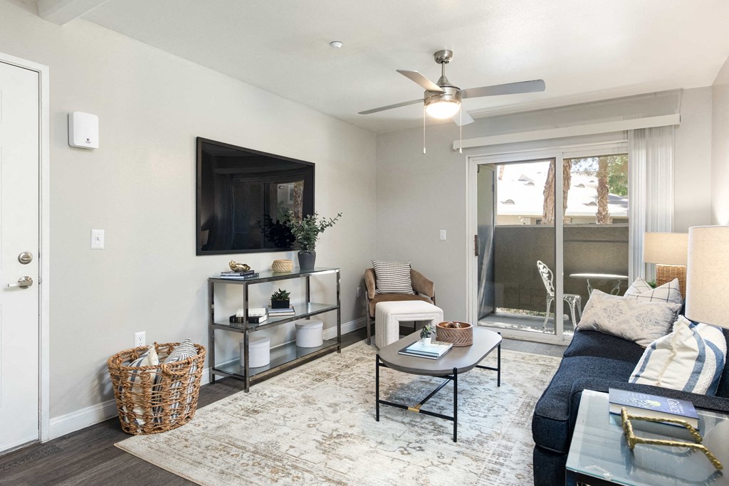 a living room with a ceiling fan and a tv