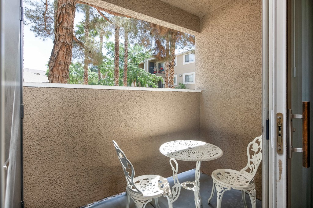 a balcony with a table and chairs and a window