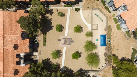 an aerial view of a backyard with a pool and trees