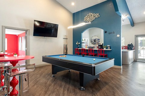a game room with a pool table and a tv