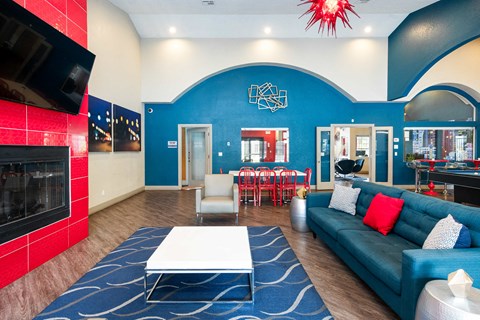 a living room with a blue couch and a table and a fireplace