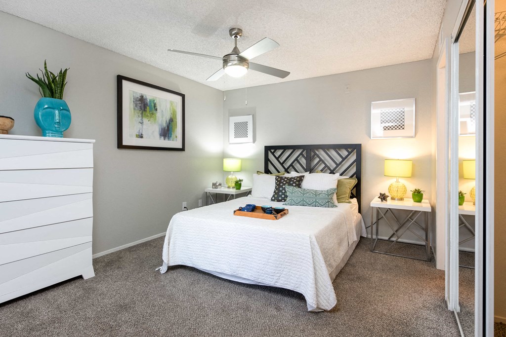 a bedroom with a bed and a ceiling fan