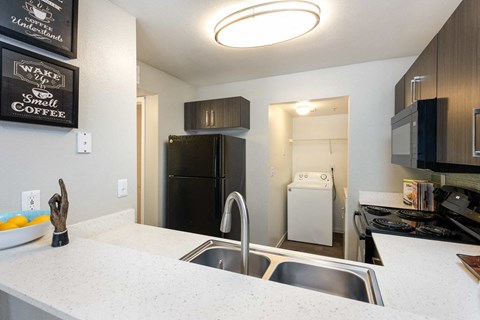 a kitchen with a sink and a counter and a refrigerator